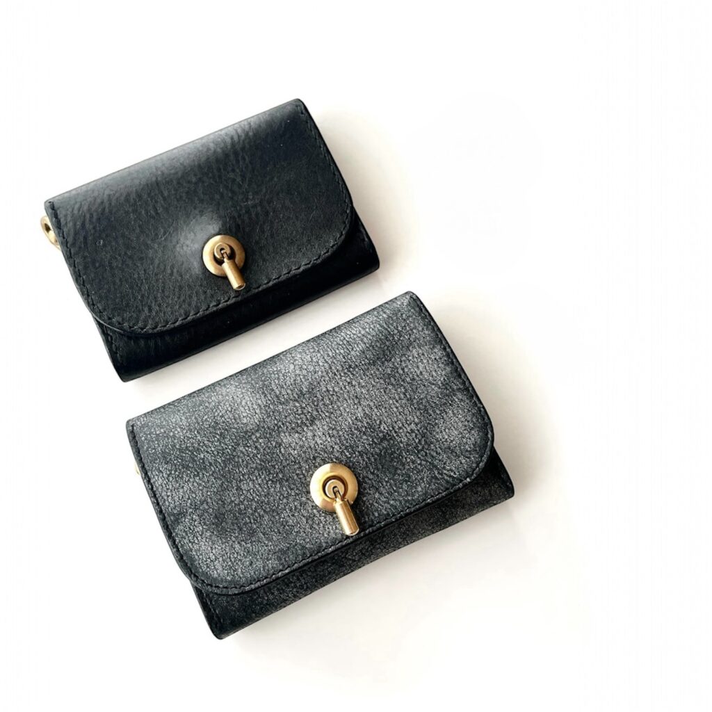 使用後エイジングした黒い名刺入れと、使用前の新品の名刺入れ。